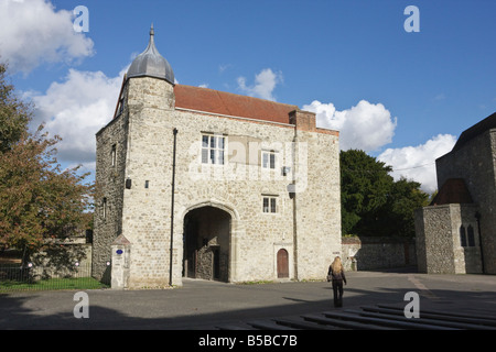 A woman Visitor passes The Gatehouse Aylesford Priory Kent in the Autumn Sunshine Stock Photo