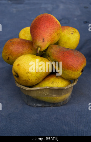 Juicy ripe forelle pears in a plastic tub on a blue background for sale at the market at the Place de la Comedie, Montpellier. Stock Photo