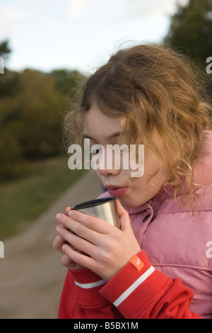 girl drinking hot chocolate from thermos Stock Photo