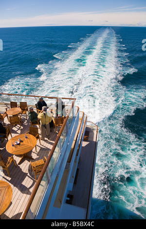 Cruise passengers visiting on outdoor dining deck while sailing the Inside Passage cruise in Alaska Stock Photo
