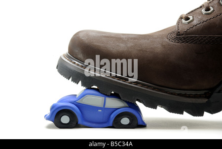 A MODEL CAR SQUASHED UNDER A MANS BOOT. Stock Photo