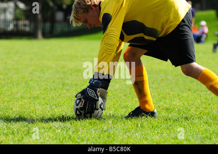 Goalie or goal keeper places soccer ball on the football field Stock Photo
