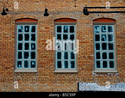 Frosted windows in a brick wall with lights on wall Stock Photo