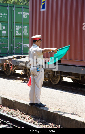 Signalman waving green flag Signal , signals and signaling at Hua Hin, Railway Station, Thailand Stock Photo