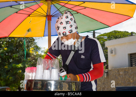 Mobile ice-cream vendor, selling ice cream, and wearing mask to provide protection against polluting vehicle emissions, Hua Hin, Thailand. Stock Photo
