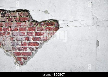 Painted grey white cement flaking off of a red brick wall, backgrounds, textures Stock Photo