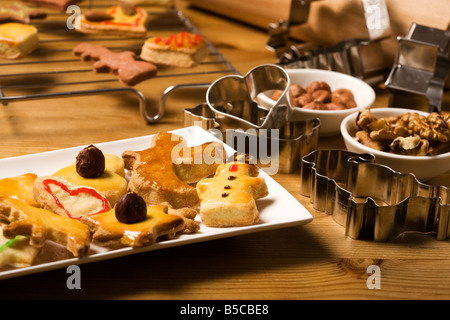 freshly made shortbread christmas cookies on a platter, baking utensils and ingredients around Stock Photo