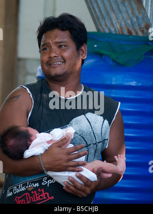 sea gypsy father and his newborn son at Rawai Beach in Phuket Thailand Stock Photo