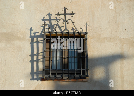 window with wrought iron bars and depiction of a cross on a house next to the Church, Chinchon, Comunidad de Madrid, Spain Stock Photo