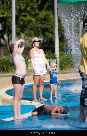 A mother and son enjoy the goings on at the giant water playground on The Strand in Townsville Stock Photo