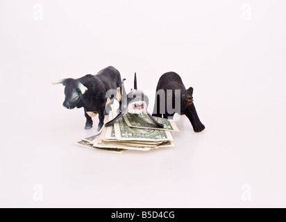 A bull and a bear surrounding a shark on a pile of money Stock Photo