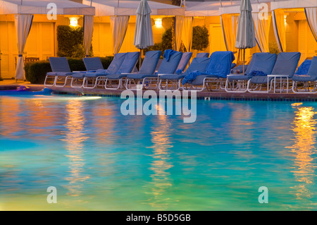 Resort Hotel Swimming Pool With Reflections And Chair Lounges In The Evening Stock Photo