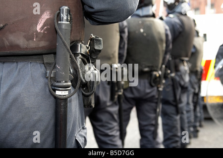 row of PSNI Police Service of Northern Ireland riot squad officers wearing batons sidearms and riot gear Stock Photo