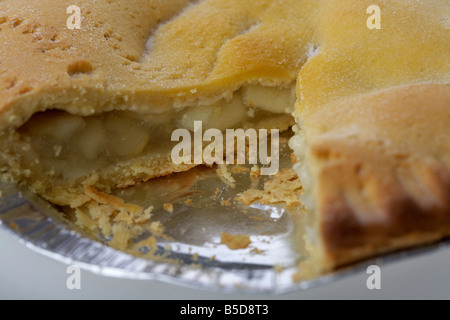 irish bramley apple pie cake in tin foil plate packaging with slice taken out Stock Photo