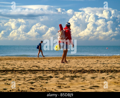 Two men going along the sandy beach, Bibione, Northern Italy Stock Photo