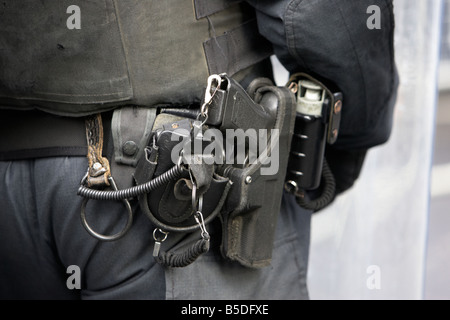 PSNI Police Service of Northern Ireland riot control officer wearing glock pistol during disturbance Stock Photo