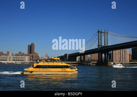 New York Water Taxi passing under the Manhattan Bridge on the East River. Stock Photo
