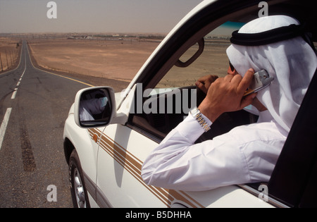 Arab businessman using mobile telephone whilst driving car in the uae Stock Photo