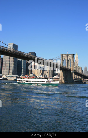 Circle Line cruise ship passing under the Brooklyn Bridge. Stock Photo