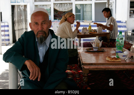 Muslim Uzbek man with traditional hat sitting in cafe, Osh market, Kyrgyzstan, Central Asia Stock Photo