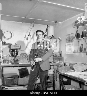 Bagpipe maker Mr. George Alexander seen here in his workshop. Circa 1960 Seen here playing a set of bagpipes he had manufactured Stock Photo