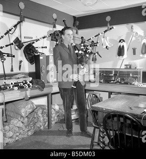 Bagpipe maker Mr. George Alexander seen here in his workshop. Circa 1960 Seen here playing a set of bagpipes he had manufactured Stock Photo