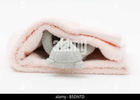Teddy bear wrapped up in folded blanket Stock Photo