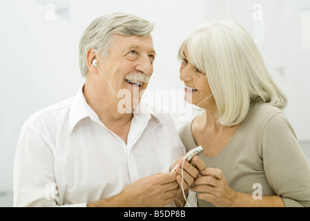 Senior couple listening to MP3 player together Stock Photo