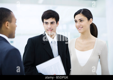 Professional woman chatting with male colleagues Stock Photo