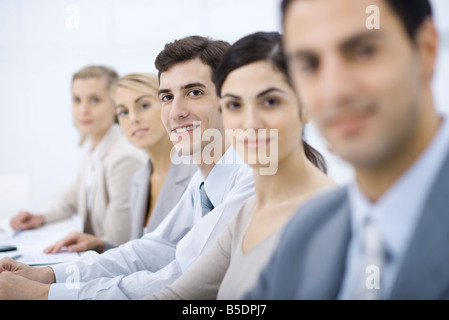 Professionals lined up, smiling at camera, selective focus Stock Photo