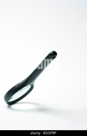 Magnifying glass tilted downward, balanced on one edge Stock Photo