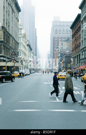 Pedestrians crossing street in crosswalk at W 19th Street and 6th Avenue Chelsea, New York, facing NE