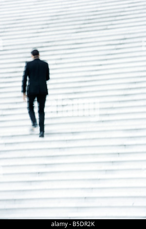 Businessman ascending stairs outdoors Stock Photo
