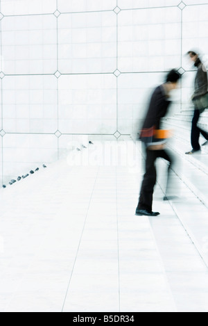 Business people passing one another going up and down steps outdoors Stock Photo
