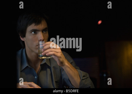 Man sipping whiskey, looking away Stock Photo