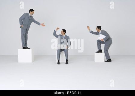 Identical businessmen congratulating each other Stock Photo