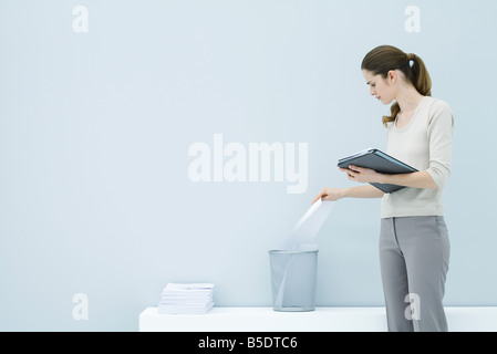 Professional woman throwing away document, holding folder Stock Photo