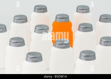 One orange bottle among group of white plastic bottles Stock Photo
