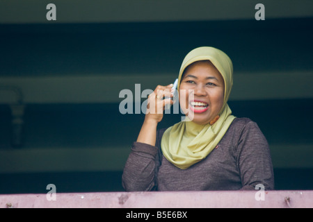 Indonesian Woman Using a Cellphone in Makassar on Sulawesi in Indonesia Stock Photo