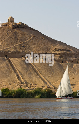 Tomb of Qubbet El Hawwa and Nobles Tombs with Felucca Sailboat on the Nile River in Aswan Egypt Stock Photo