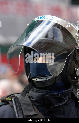 PSNI Police Service of Northern Ireland female police officer wearing riot helmet and visor watching Stock Photo
