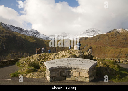 Eryri Snowdonia National Park Gwynedd North Wales UK October Group of sightseers looking across to the snow covered Snowdon Mountain Stock Photo
