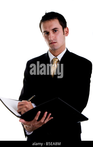 A young businessman writing on a pad and looking at camera Stock Photo