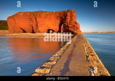 The bright red Langstone Rock on Dawlish seafront viewed fromthe breakwater Dawlish Devon UK Stock Photo