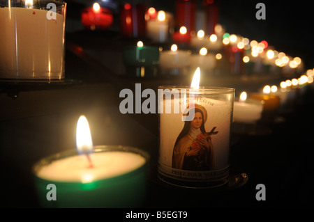 Candles with a virgin Mary icon burning inside a church in central France Stock Photo