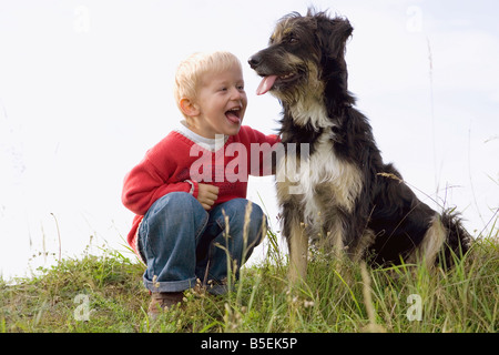 Little boy (3-4) playing with dog Stock Photo