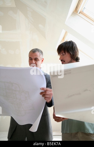 Two men looking at construction plan Stock Photo