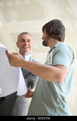 Two men looking at construction plan Stock Photo