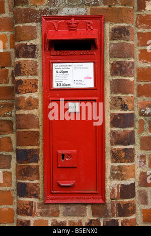 red post box in a wall in UK Stock Photo