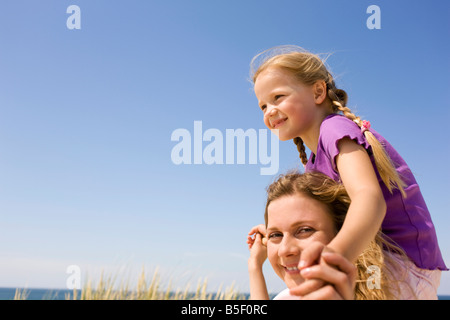 Germany, Baltic sea, Mother carrying daughter (6-7) on shoulders, portrait Stock Photo